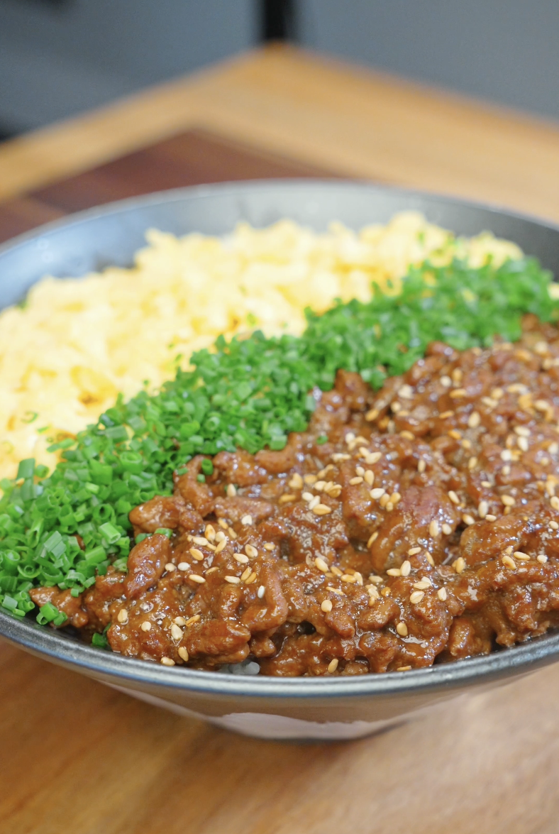 Japanese Ground Beef Egg Bowl Recipe served with fluffy scrambled eggs, chopped chives, sesame seeds, and savory glazed ground beef over rice.