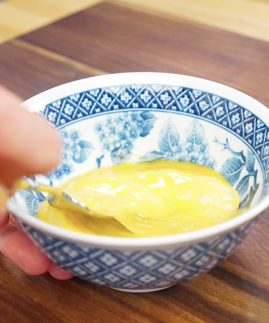 Eggs being whisked in a patterned bowl until smooth and fully combined to prepare fluffy scrambled eggs for this Chili Oil Butter Fried Rice Recipe.