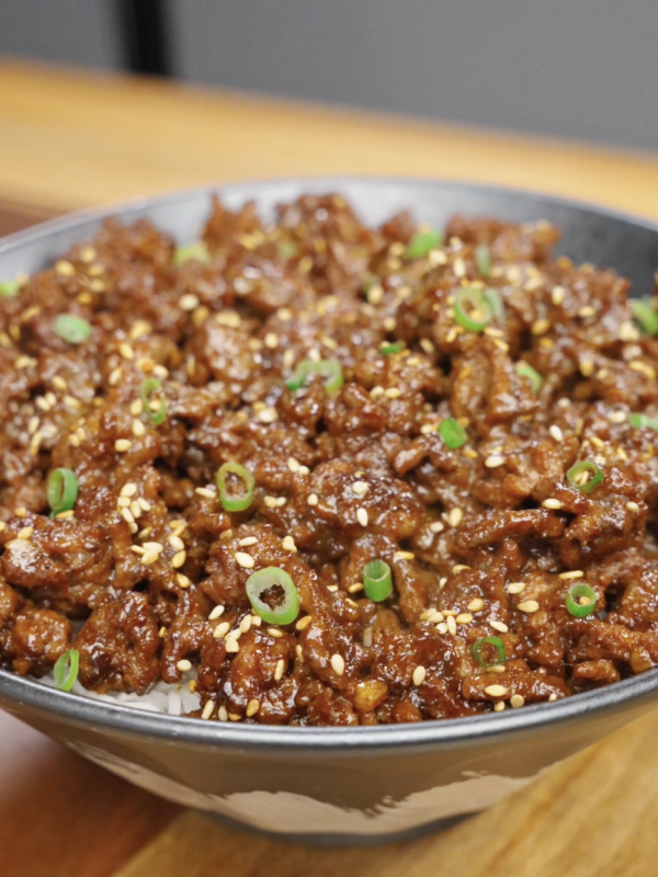 Bowl of Sticky Ground Beef Recipe served over steamed rice and garnished with sesame seeds and scallions for an easy high-protein dinner.