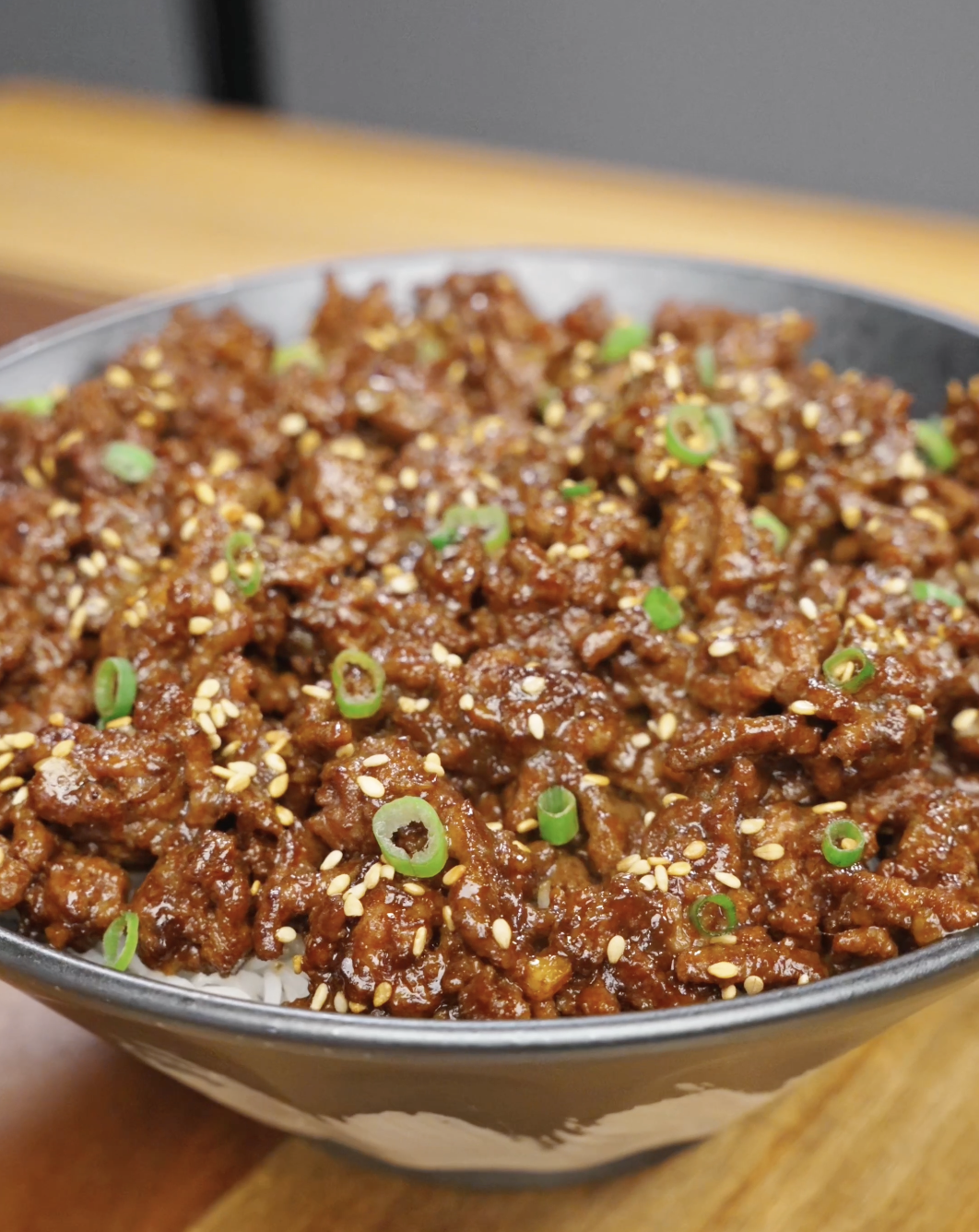 Bowl of Sticky Ground Beef Recipe served over steamed rice and garnished with sesame seeds and scallions for an easy high-protein dinner.