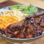 Bowl of Vietnamese-inspired lemongrass beef served over steamed rice with fresh cilantro, shredded carrots, and crispy onions for a flavorful and balanced weeknight dinner.