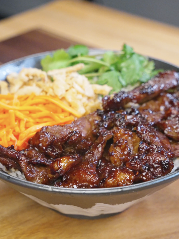 Bowl of Vietnamese-inspired lemongrass beef served over steamed rice with fresh cilantro, shredded carrots, and crispy onions for a flavorful and balanced weeknight dinner.