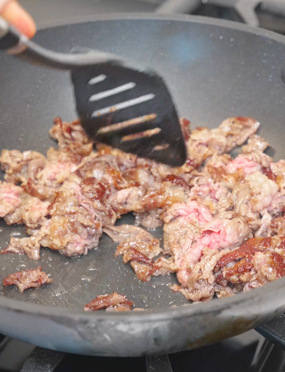Thinly sliced beef searing in a hot pan until lightly browned for the Mongolian Beef Noodles Recipe.