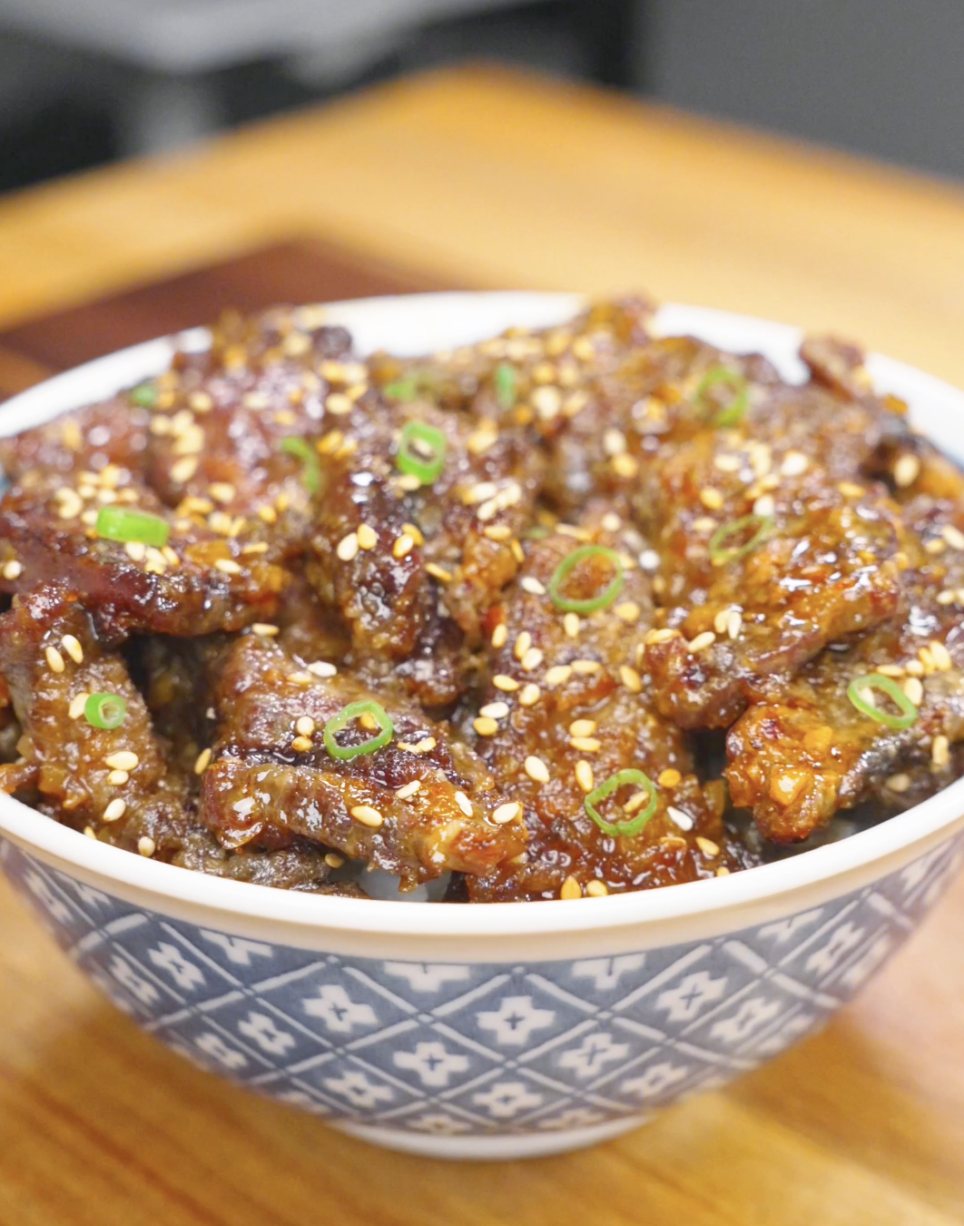 Bowl of Crispy Honey Garlic Beef Recipe coated in a glossy honey garlic sauce and topped with sesame seeds and sliced scallions. This easy air fryer beef recipe delivers crispy, tender bites with sweet and savory flavor.