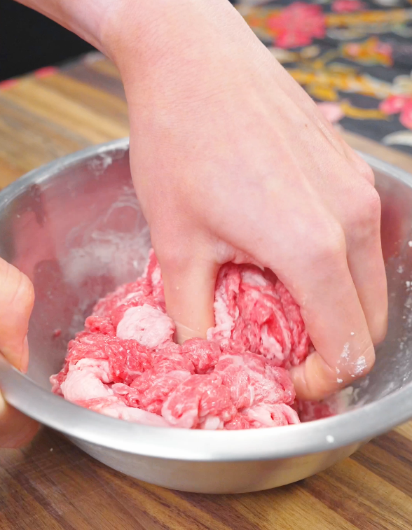 Thinly sliced beef being mixed with cornstarch, Shaoxing wine, and salt for the Mongolian Beef Noodles Recipe.