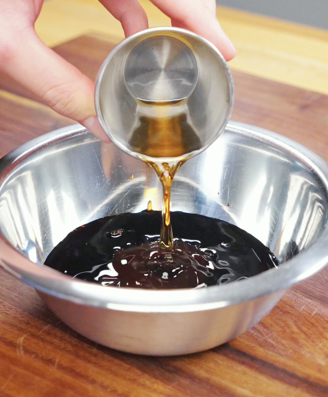 Dark soy sauce, light soy sauce, oyster sauce, fish sauce, sugar, and water being combined for a Drunken Noodles Recipe. This savory sauce gives Pad Kee Mao its signature flavor.