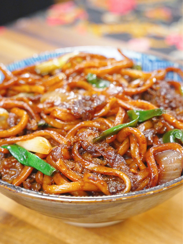Mongolian Beef Noodles Recipe served in a bowl with tender beef, chewy noodles, onions, and scallions coated in a savory sauce.