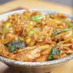 A bowl of Pad See Ew Recipe made with wide rice noodles, chicken, Chinese broccoli, egg, and a savory soy sauce glaze.