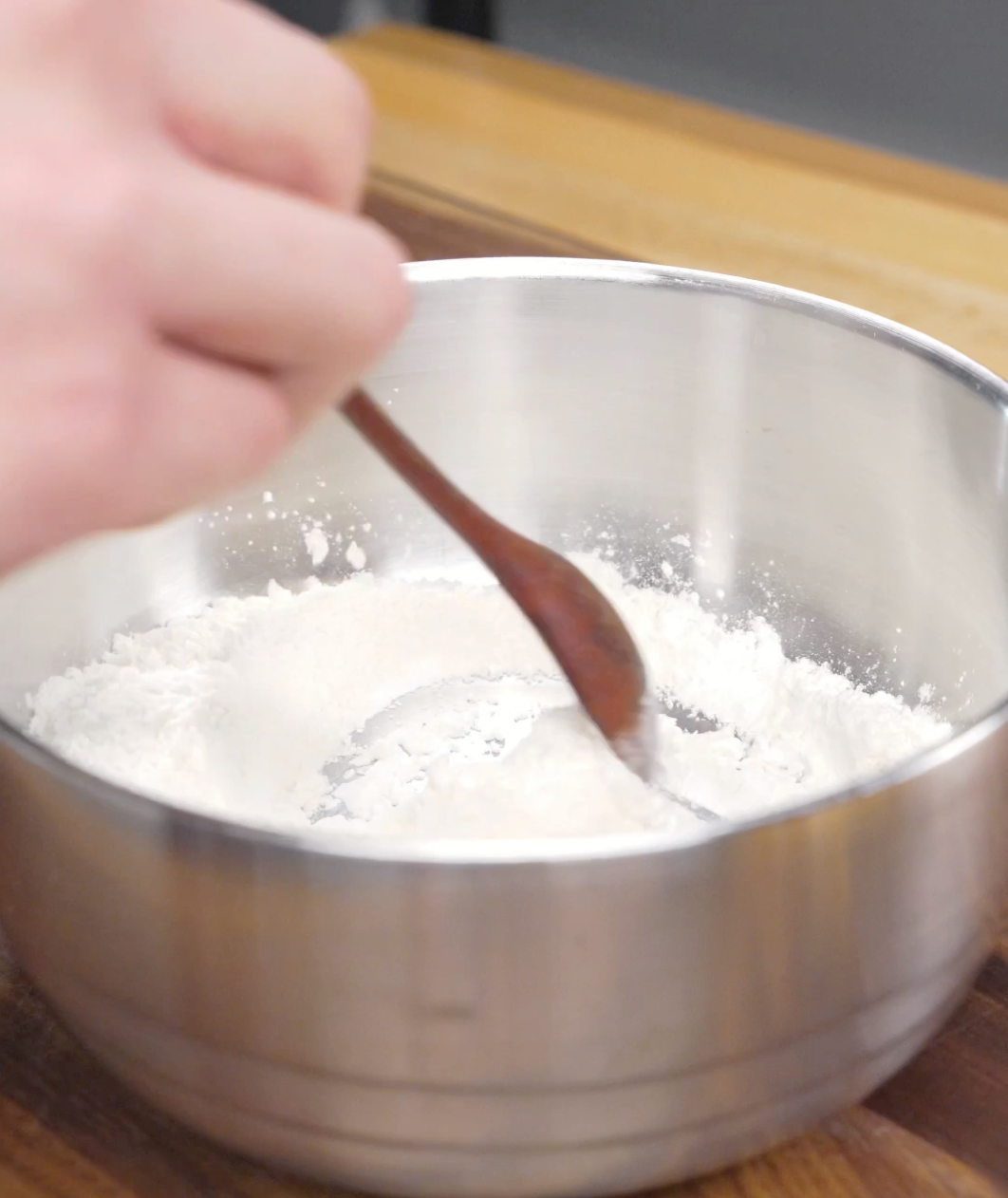 Flour, cornstarch, and salt being mixed together in a bowl to create the crispy coating used in this Crispy Chili Beef Recipe.