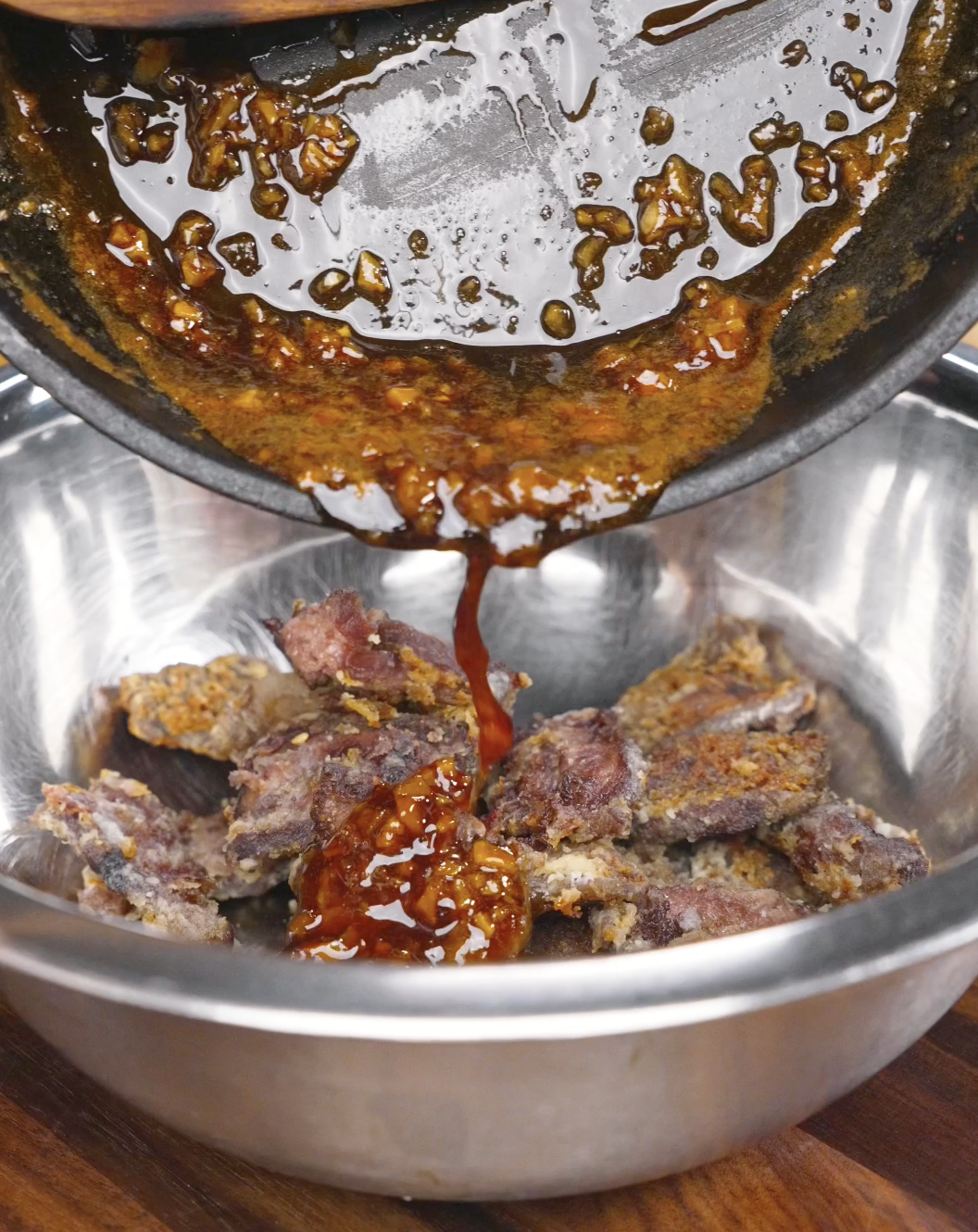 Thick honey garlic sauce being poured over crispy beef for a Crispy Honey Garlic Beef Recipe. The sauce combines soy sauce, honey, garlic, and rice vinegar for a flavorful glaze.