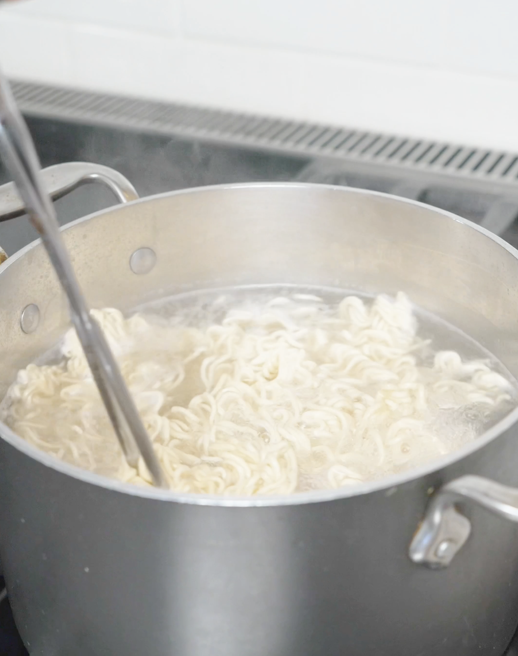 Instant noodles cooking in a pot of boiling water for the Creamy Garlic Butter Noodles Recipe.