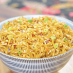 Creamy Garlic Butter Noodles Recipe served in a bowl with a rich garlic butter sauce, sesame seeds, scallions, and red pepper flakes.