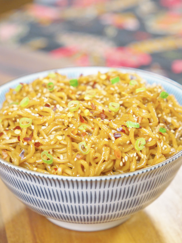 Creamy Garlic Butter Noodles Recipe served in a bowl with a rich garlic butter sauce, sesame seeds, scallions, and red pepper flakes.
