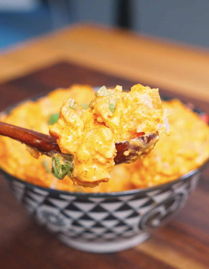 Chopsticks lifting a creamy, roe-flecked bite above the bowl of Creamy Salmon Poke Recipe.