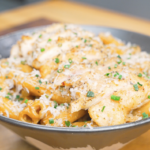Finished Creamy Garlic Chicken Pasta Recipe topped with sliced chicken, Parmesan, black pepper, and chives.