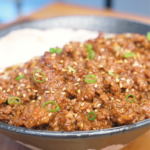 Finished Garlic Ground Beef Recipe over rice topped with sesame seeds, scallions, and a fried egg.