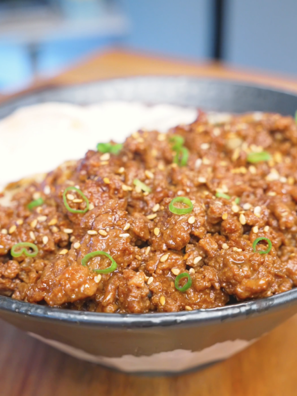 Finished Garlic Ground Beef Recipe over rice topped with sesame seeds, scallions, and a fried egg.