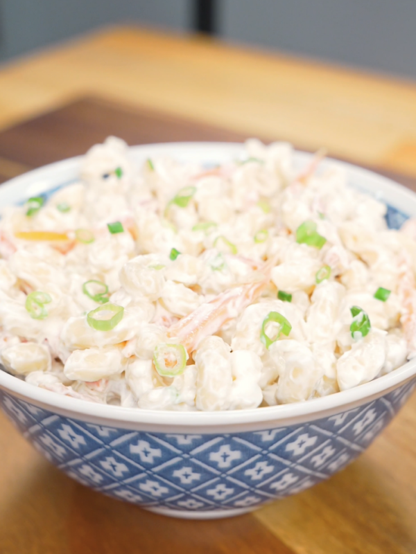 Finished Hawaiian Mac Salad Recipe in a blue bowl with shredded carrots and sliced scallions.