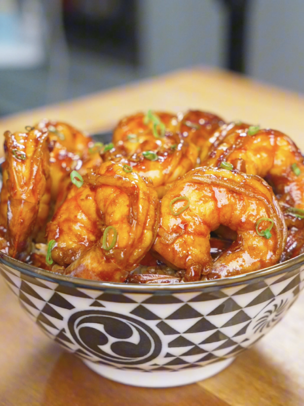 Finished Honey Garlic Shrimp Recipe served over rice in a patterned bowl and topped with scallions.