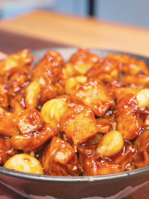 Finished Sticky Garlic Chicken Recipe in a bowl with glazed chicken chunks and whole garlic cloves.
