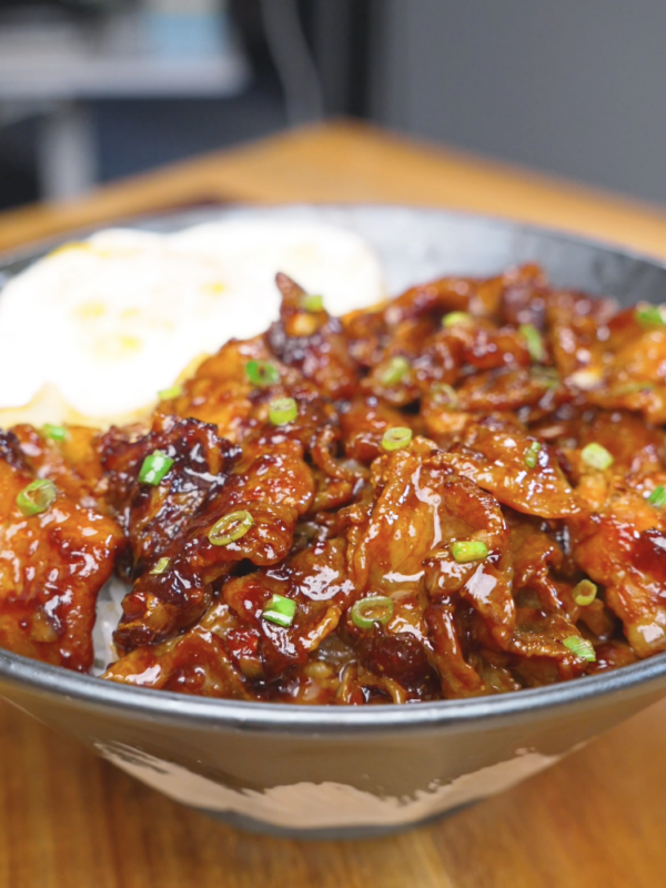 Finished Sticky Sweet Pork Belly Recipe over rice with scallions and a fried egg.