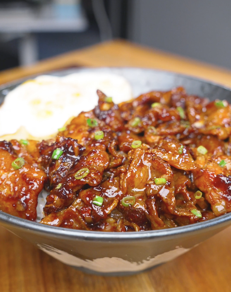 Finished Sticky Sweet Pork Belly Recipe over rice with scallions and a fried egg.