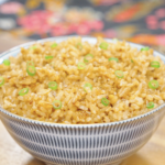 A bowl of Garlic Butter Fried Rice Recipe garnished with fresh scallions and ready to serve.