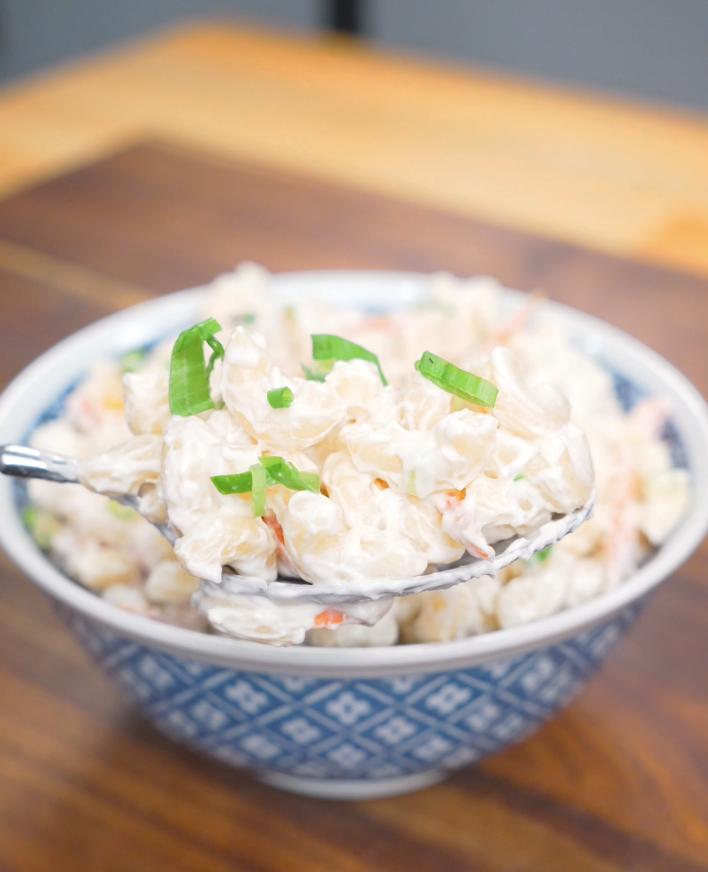 A spoonful of creamy macaroni lifted from the bowl of Hawaiian Mac Salad Recipe.