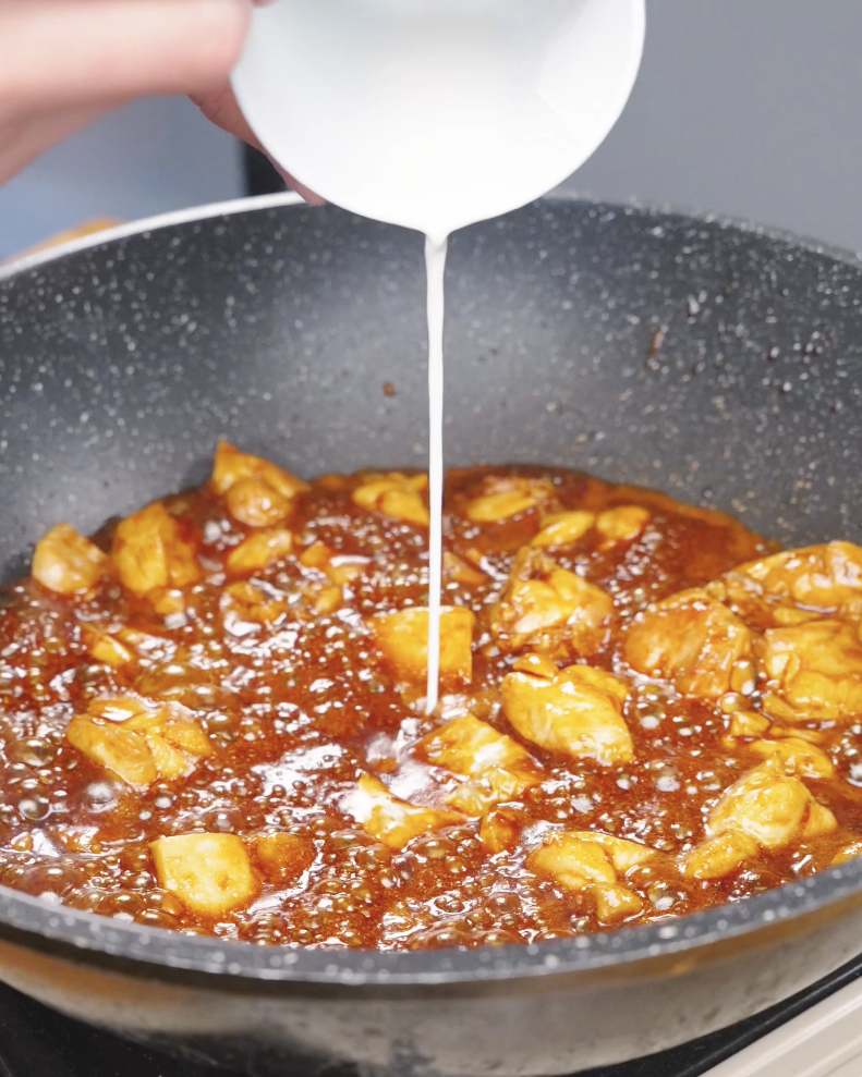 A cornstarch slurry being poured into the simmering sauce to thicken it for Sticky Soy Garlic Chicken Recipe.