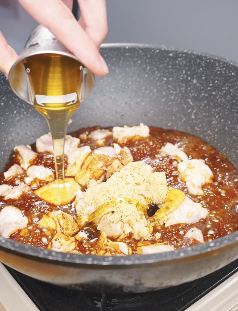 Honey being poured over a mound of brown sugar and chicken in the soy sauce for Sticky Soy Garlic Chicken Recipe.