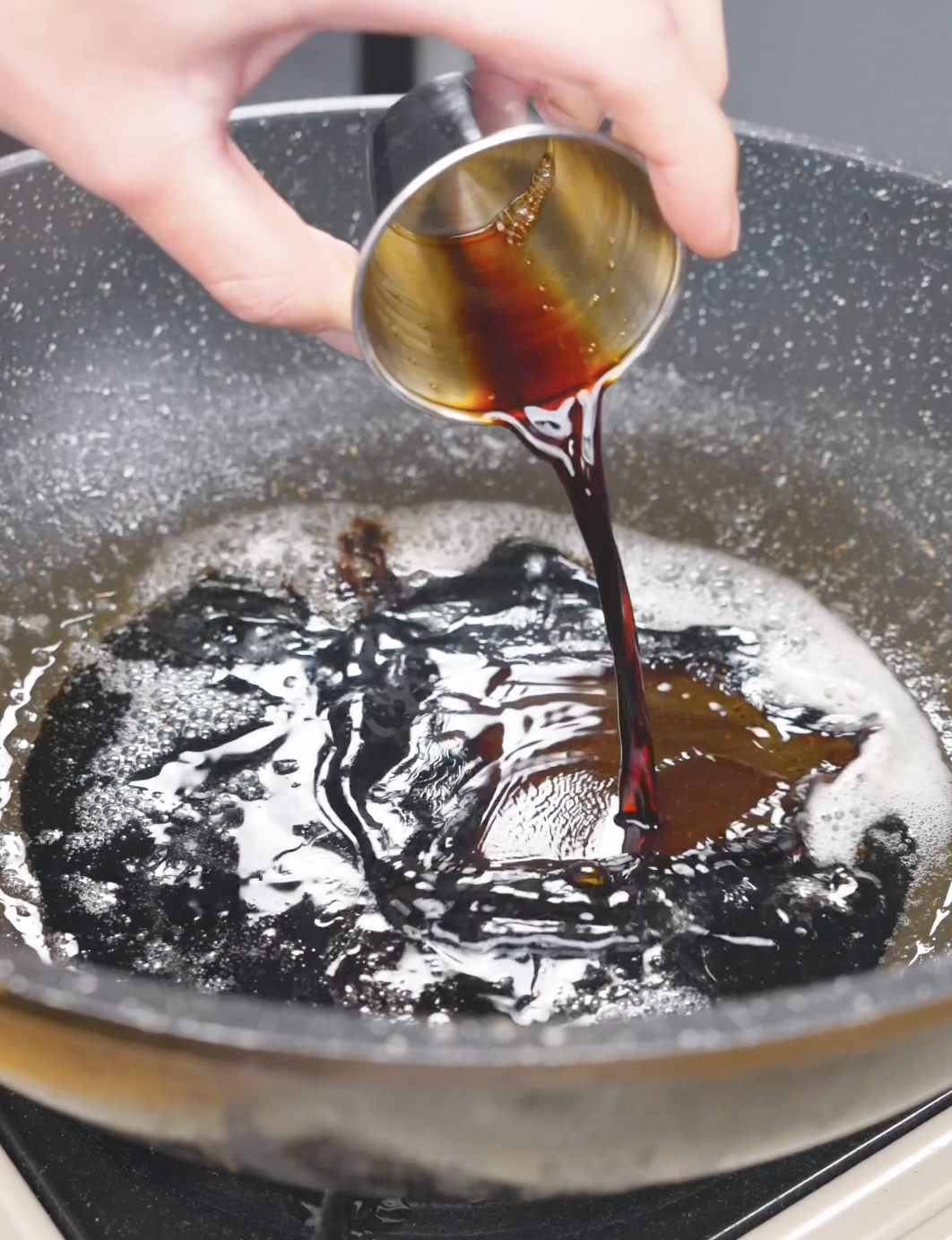 Dark soy sauce being poured into the melted butter in the pan for Soy Butter Noodles Recipe.
