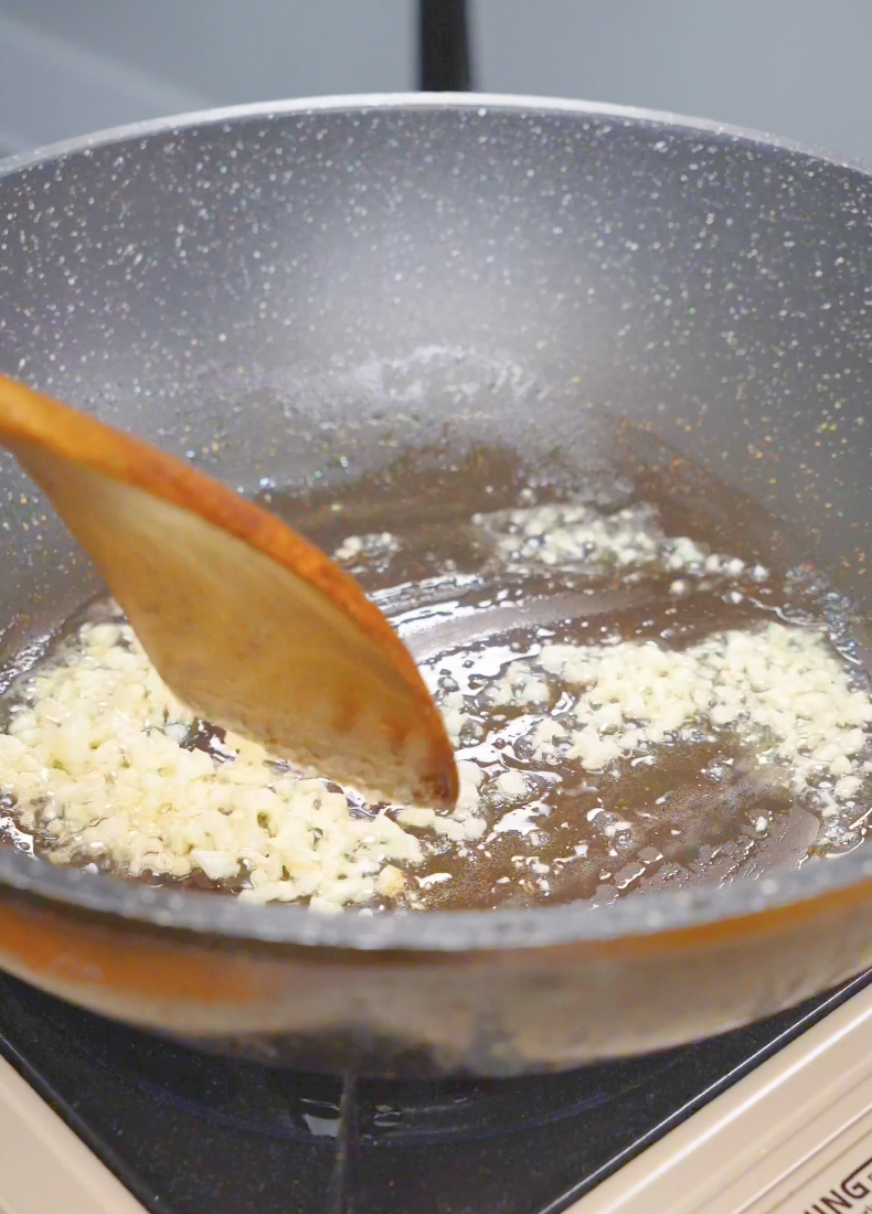 Minced garlic sizzling in melted butter in a pan while starting Creamy Miso Butter Noodles Recipe.