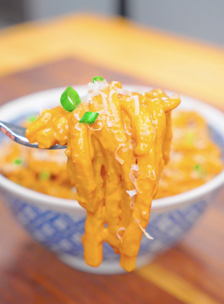 A fork lifting a twirl of creamy, sauce-coated noodles above the bowl of Creamy Miso Butter Noodles Recipe.