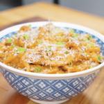 Finished Creamy Miso Butter Noodles Recipe in a blue bowl topped with Parmesan, black pepper, and scallions.