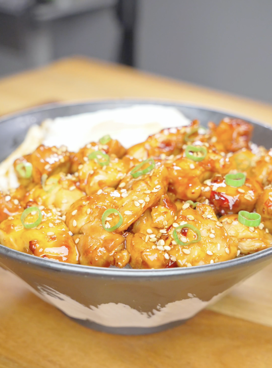 Finished Firecracker Chicken Recipe served over rice with sesame seeds, scallions, and a fried egg.