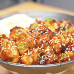 Finished Honey BBQ Chicken Recipe over rice with sesame seeds, scallions, and a fried egg.
