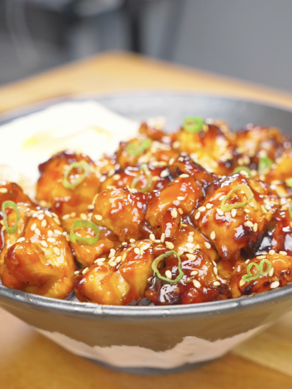 Finished Honey BBQ Chicken Recipe over rice with sesame seeds, scallions, and a fried egg.
