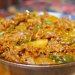 Finished Kimchi Beef Stir Fry Recipe in a ceramic bowl with beef, kimchi, and scallions.