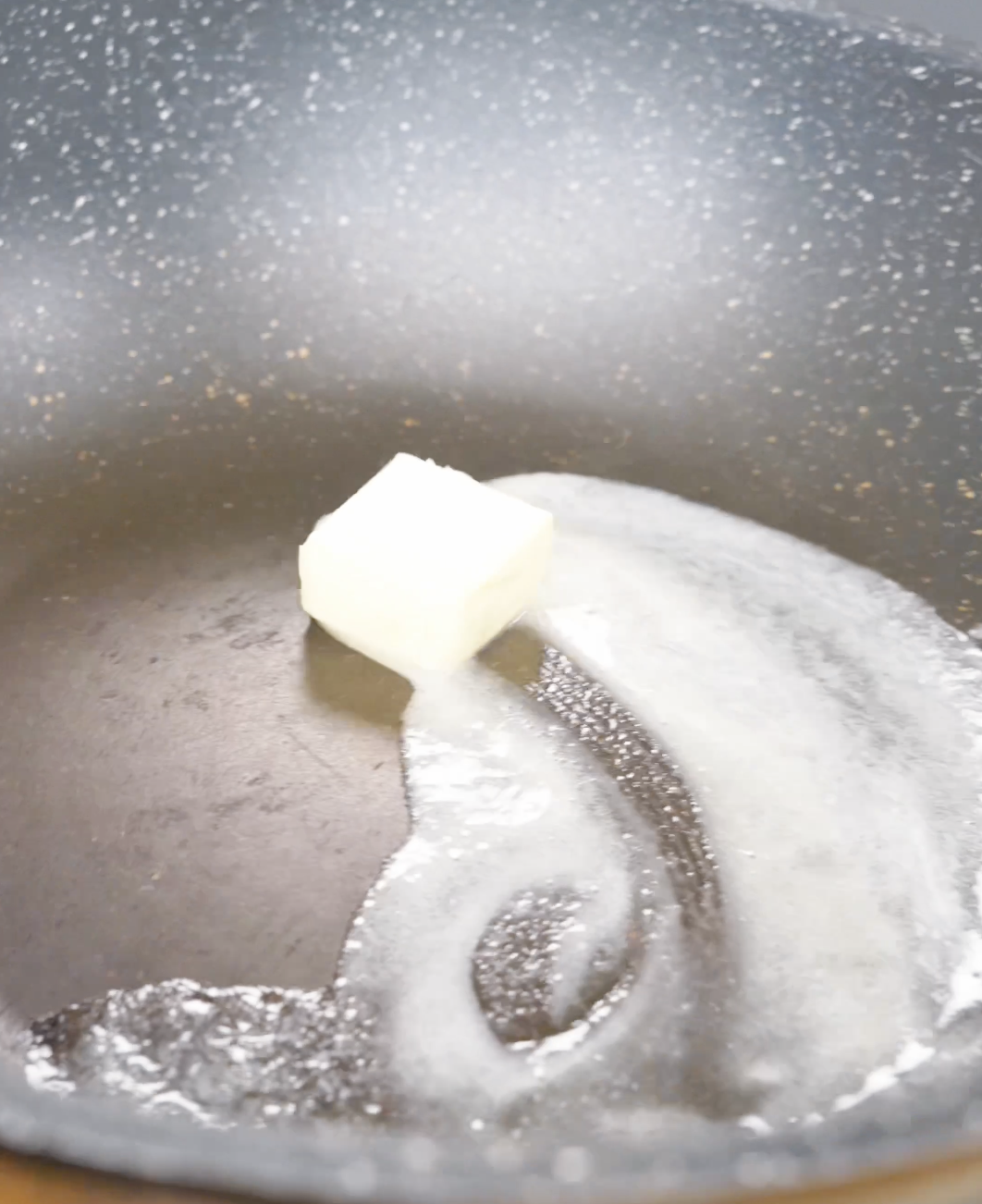 A pat of butter melting in a hot pan while starting Soy Butter Noodles Recipe.