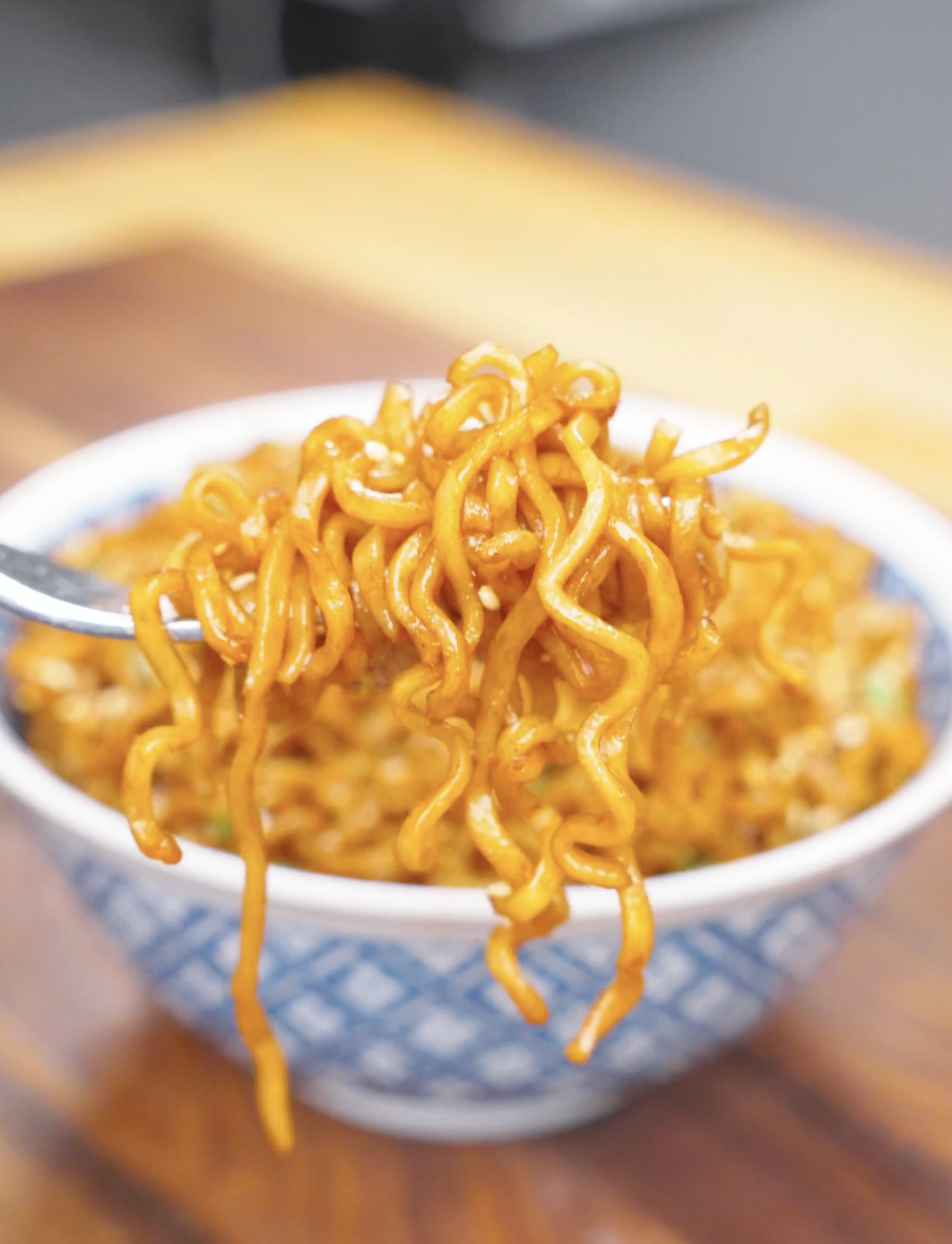 A fork lifting a twirl of glossy noodles above the bowl of Soy Butter Noodles Recipe.