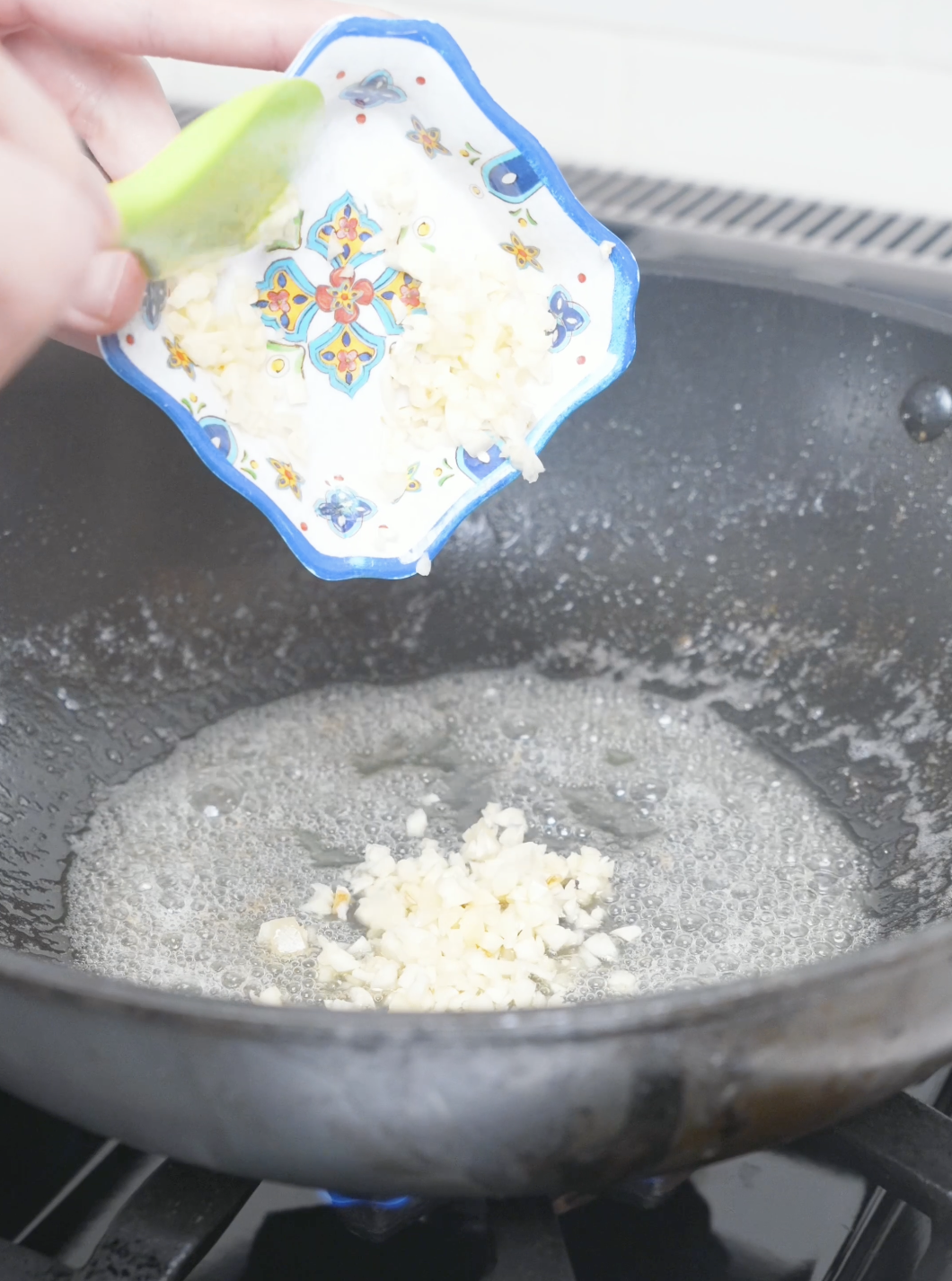 Minced garlic being tipped into a pan of melted butter for Garlic Butter Shrimp Recipe.