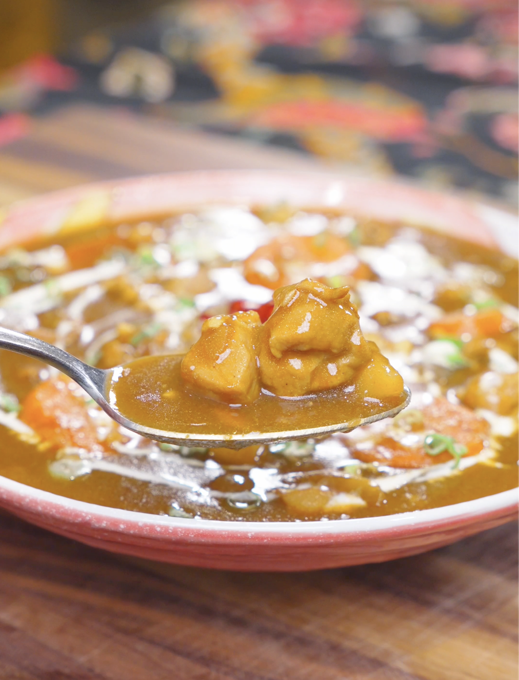 A spoon lifting tender chicken and potato from the bowl of Chicken Curry Stew Recipe.