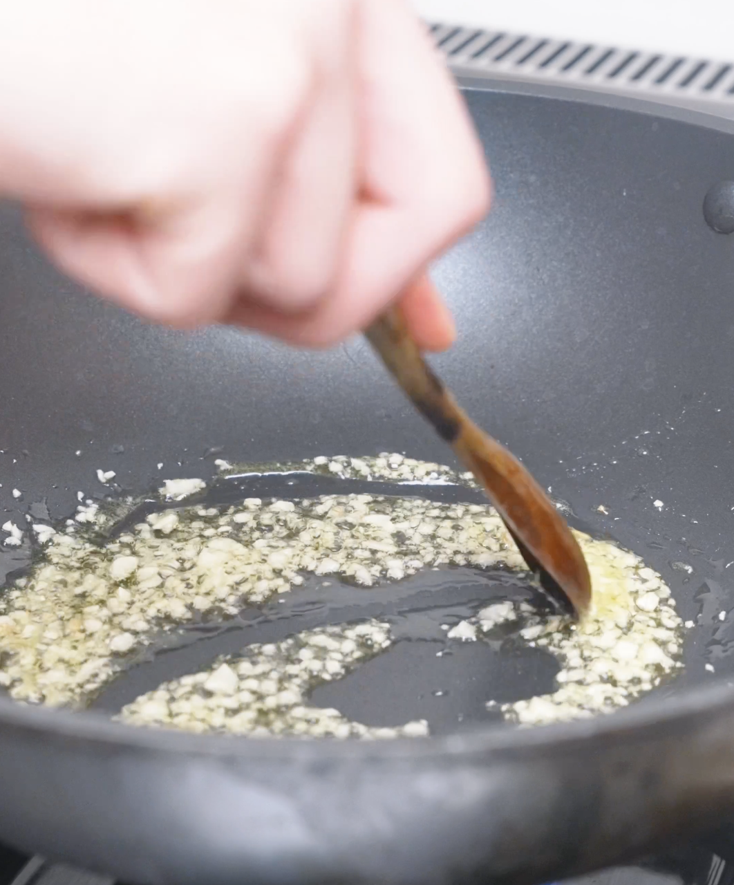 Minced garlic sizzling in oil in a pan until fragrant while starting Creamy Curry Noodles Recipe.