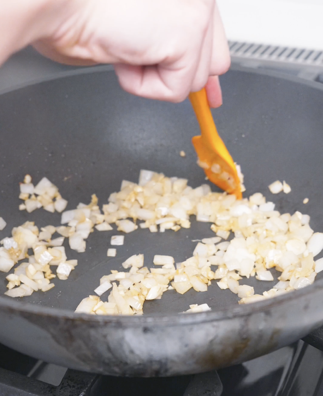 Diced onion, garlic, and ginger softening in the wok until fragrant for Curry Fried Rice Recipe.