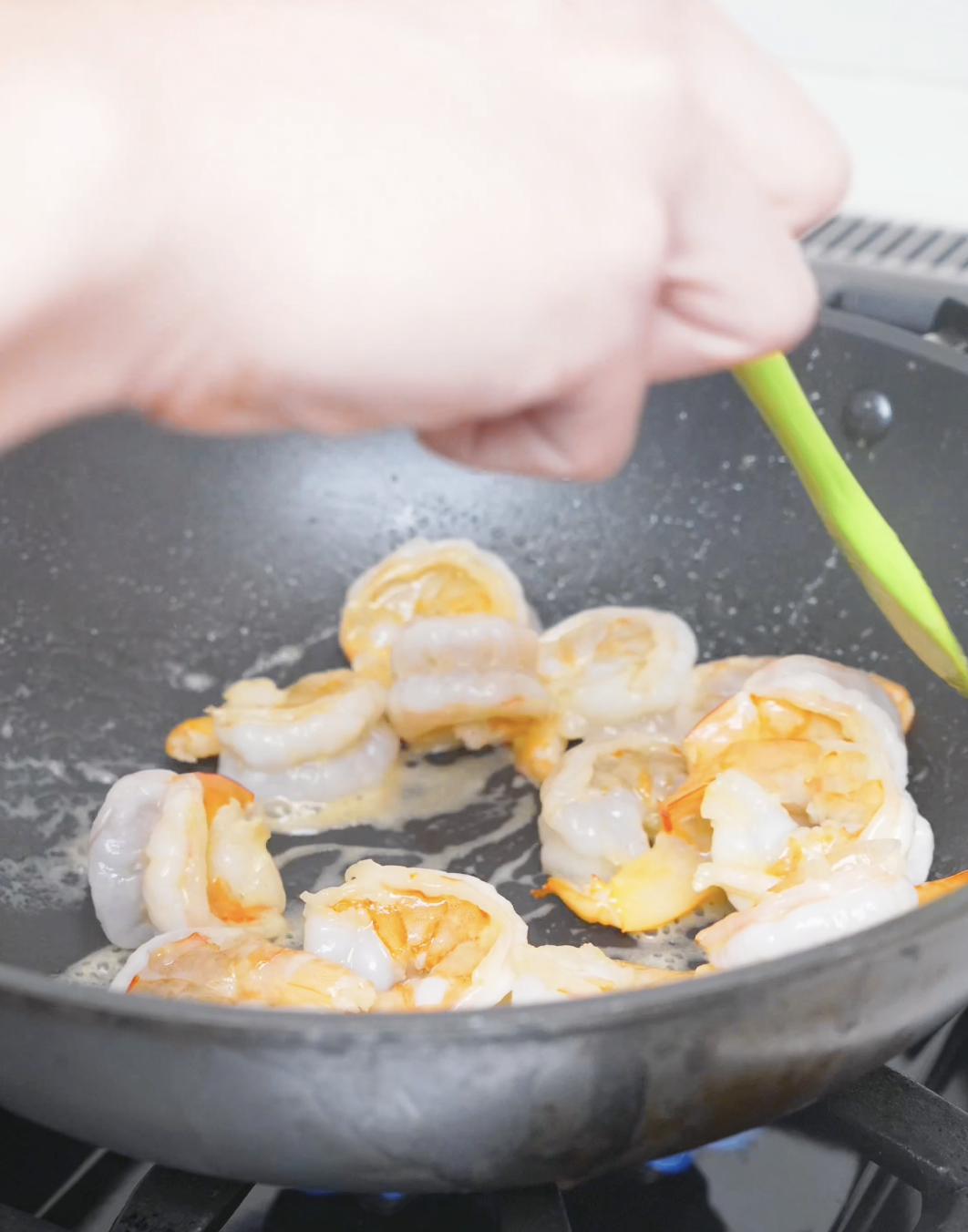 Raw shrimp cooking in a pan until mostly pink for Garlic Butter Shrimp Recipe.
