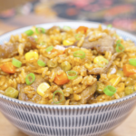 Finished Curry Fried Rice Recipe in a patterned bowl with beef, peas, corn, carrots, and scallions.