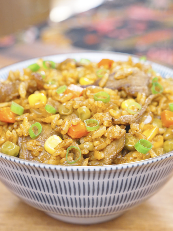 Finished Curry Fried Rice Recipe in a patterned bowl with beef, peas, corn, carrots, and scallions.