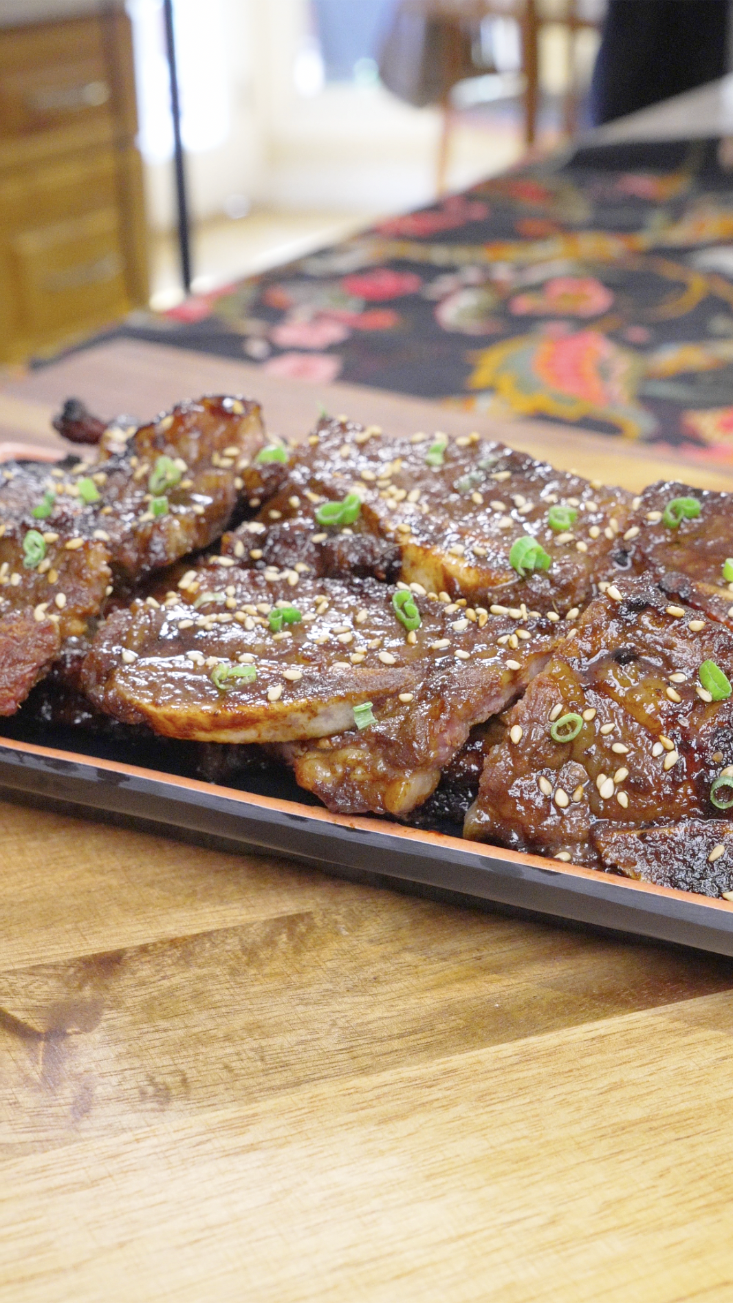 Finished Korean BBQ Short Rib Recipe on a platter with charred edges, sesame seeds, and scallions.