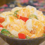 Finished Salt and Pepper Shrimp Recipe in a dark bowl with crispy shell-on shrimp, red bell pepper, and jalapeño.