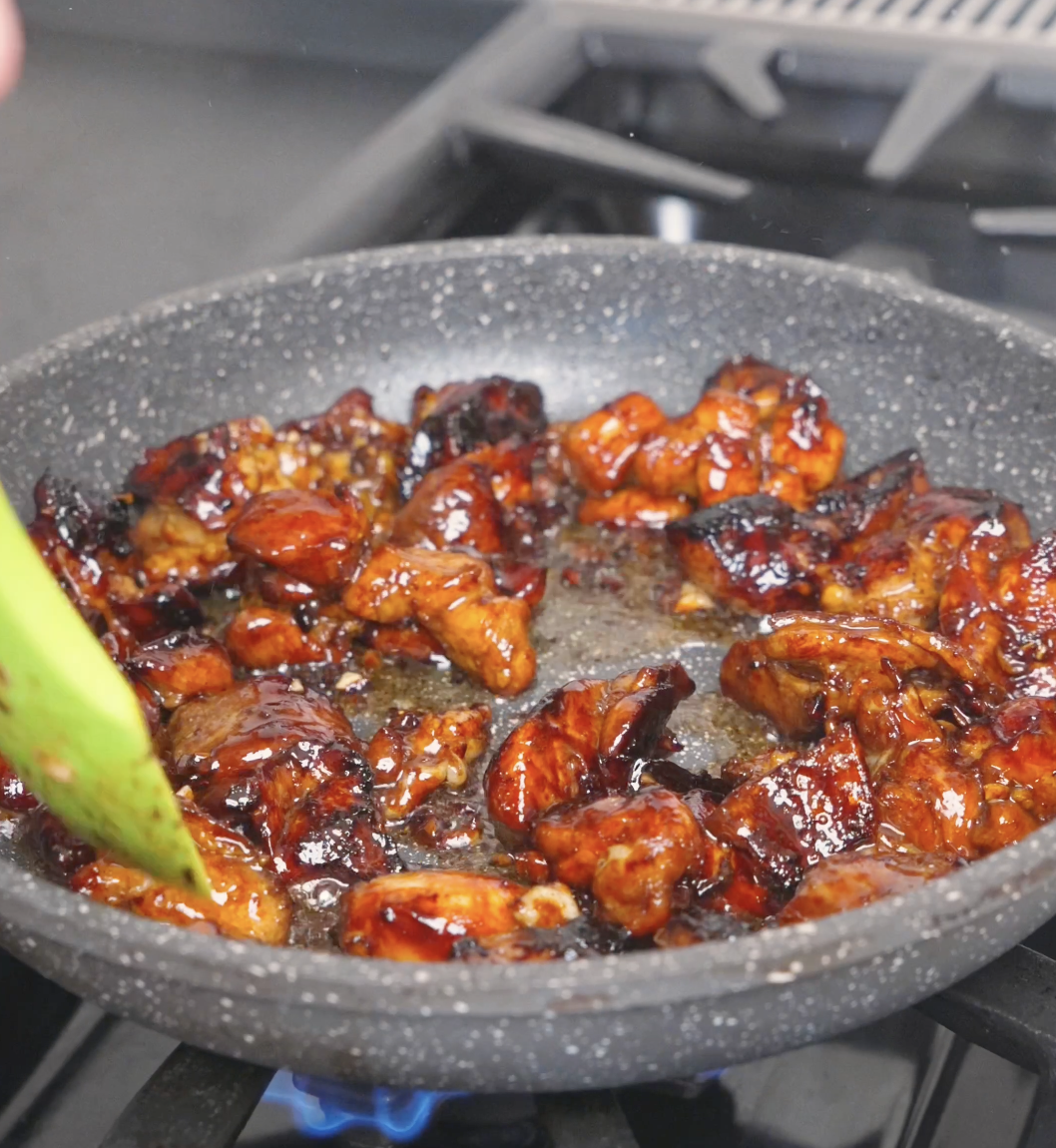 Chicken caramelizing as the marinade reduces into a dark, glossy glaze for Garlic Teriyaki Chicken Recipe.